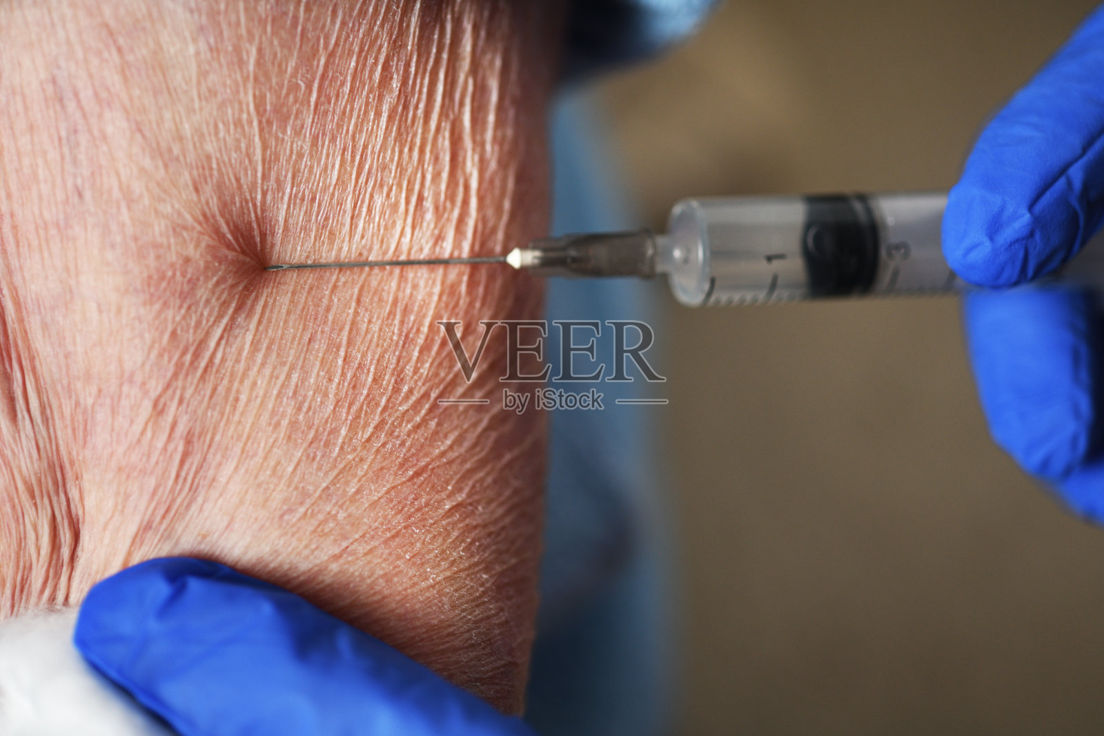 医生给一名90岁的妇女接种covid-19疫苗。为老年人接种疫苗。老年妇女在养老院接受COVID-19疫苗接种。照片摄影图片