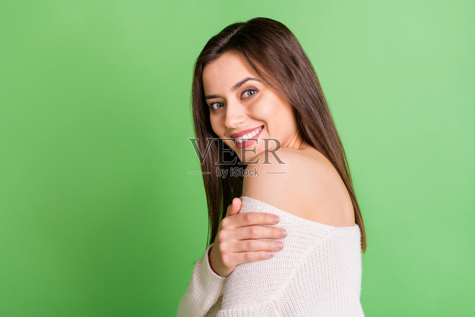 年轻美丽的侧面照片，微笑，快乐，积极，好心情女孩拥抱自己孤立在绿色的背景照片摄影图片