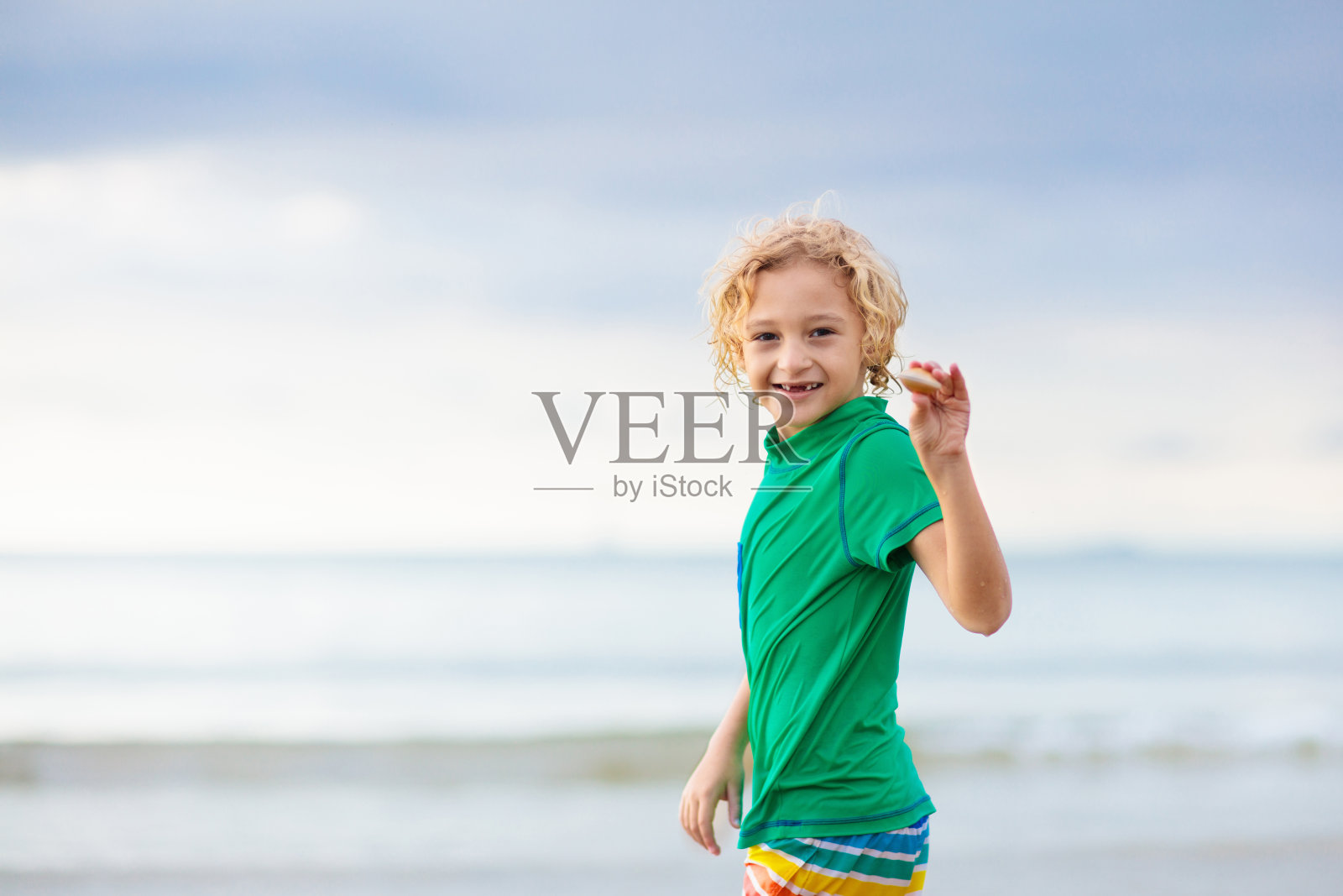 孩子们在热带海滩上玩耍。沙子和水玩具。照片摄影图片