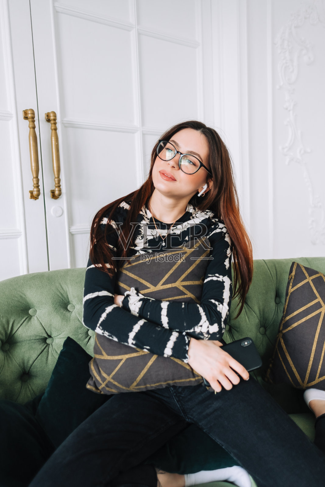 迷人的白人女人戴着耳机在舒适的沙发上放松在家里听音乐…照片摄影图片