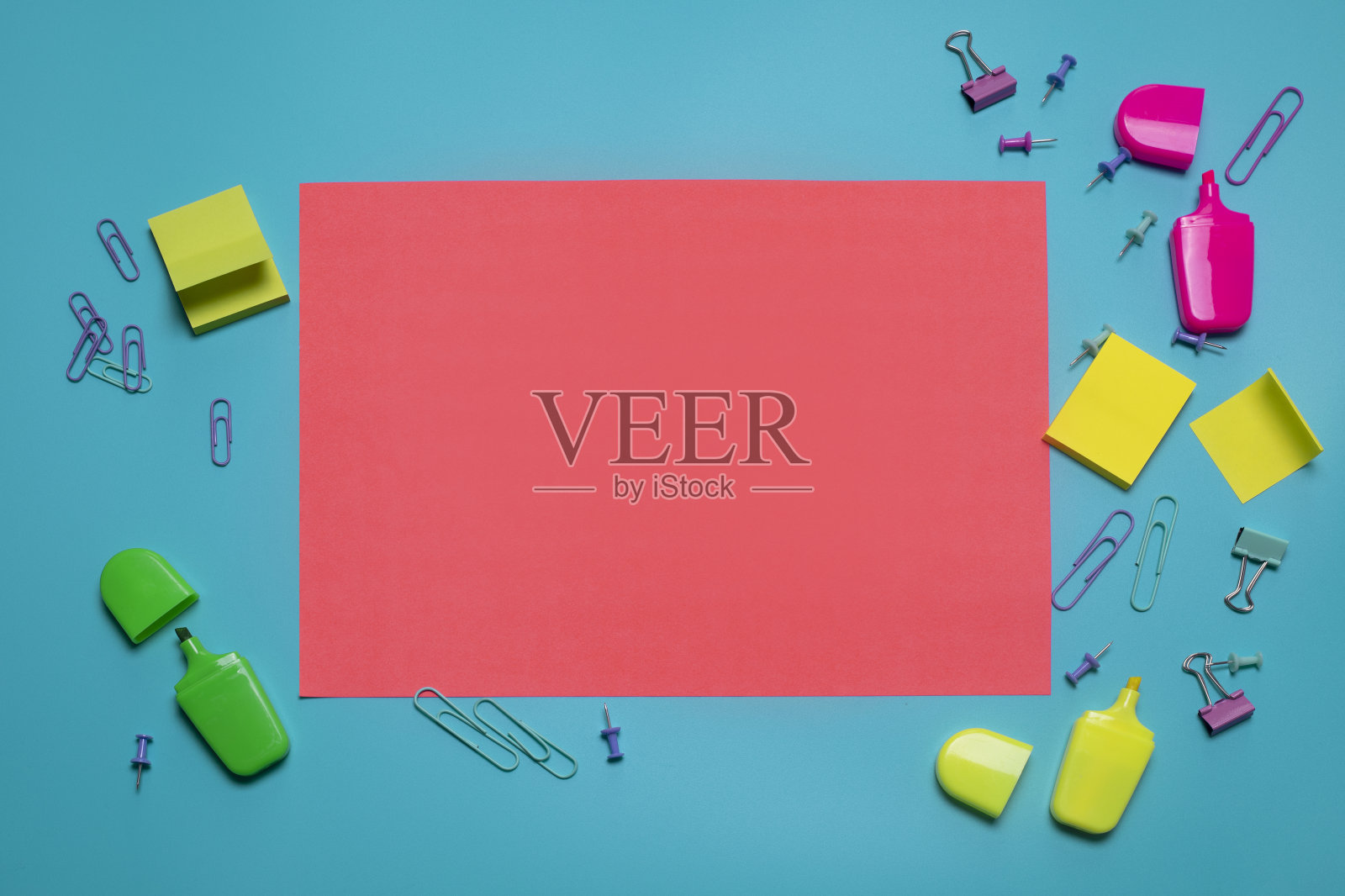 文具项目在蓝色背景与自由空间的文字。创意，丰富多彩的背景与学校或办公用品。平躺与拷贝空间，俯视图。马克笔，回形针，便利贴。照片摄影图片