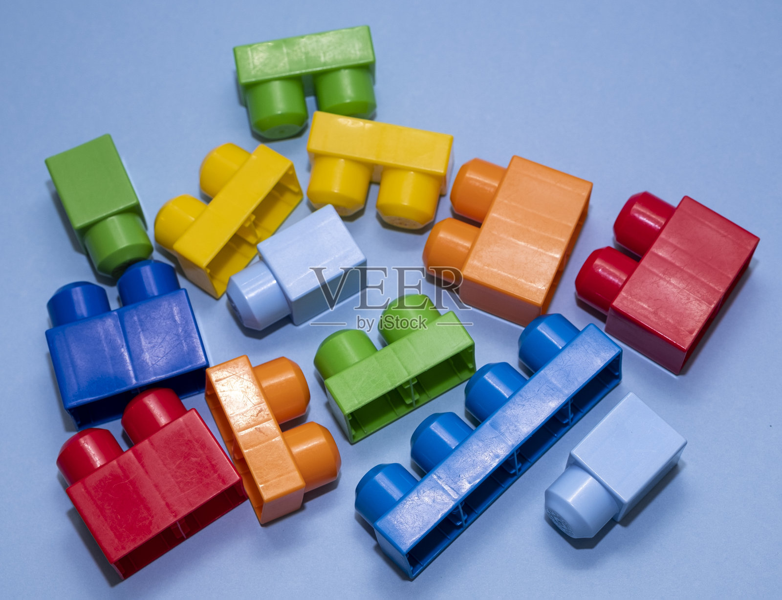 用于连接和建造游戏结构的塑料砖。儿童玩具，构造师，蓝色背景。照片摄影图片