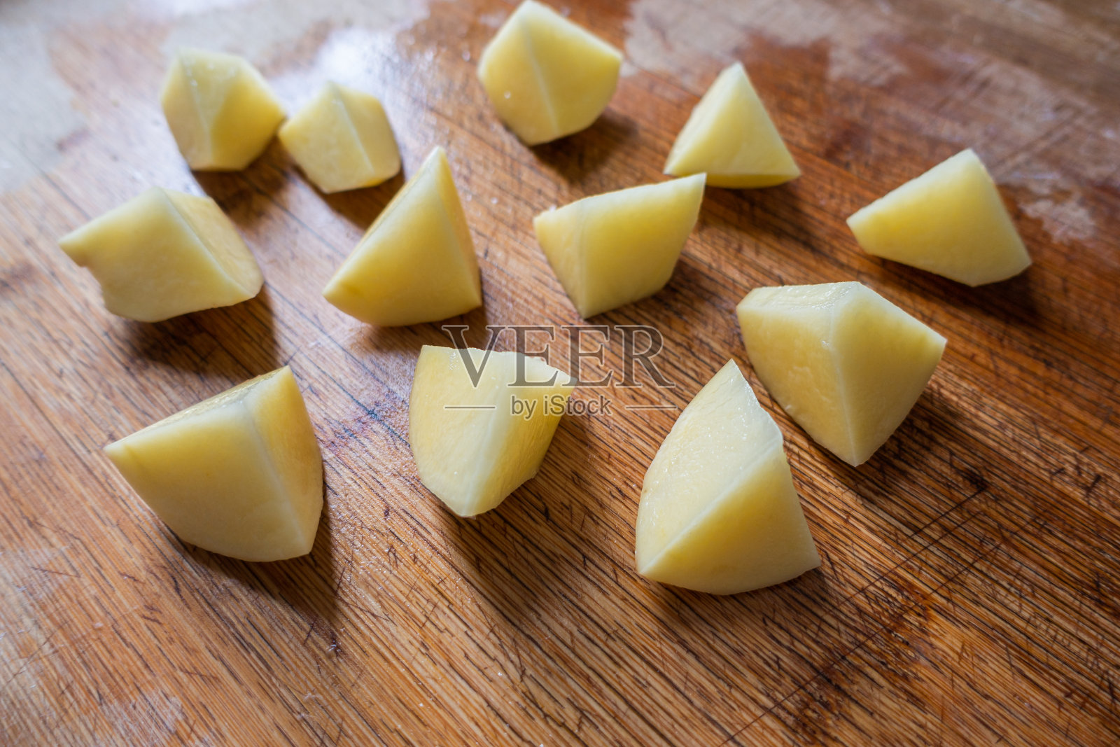 在厨房木板上切新鲜的土豆照片摄影图片