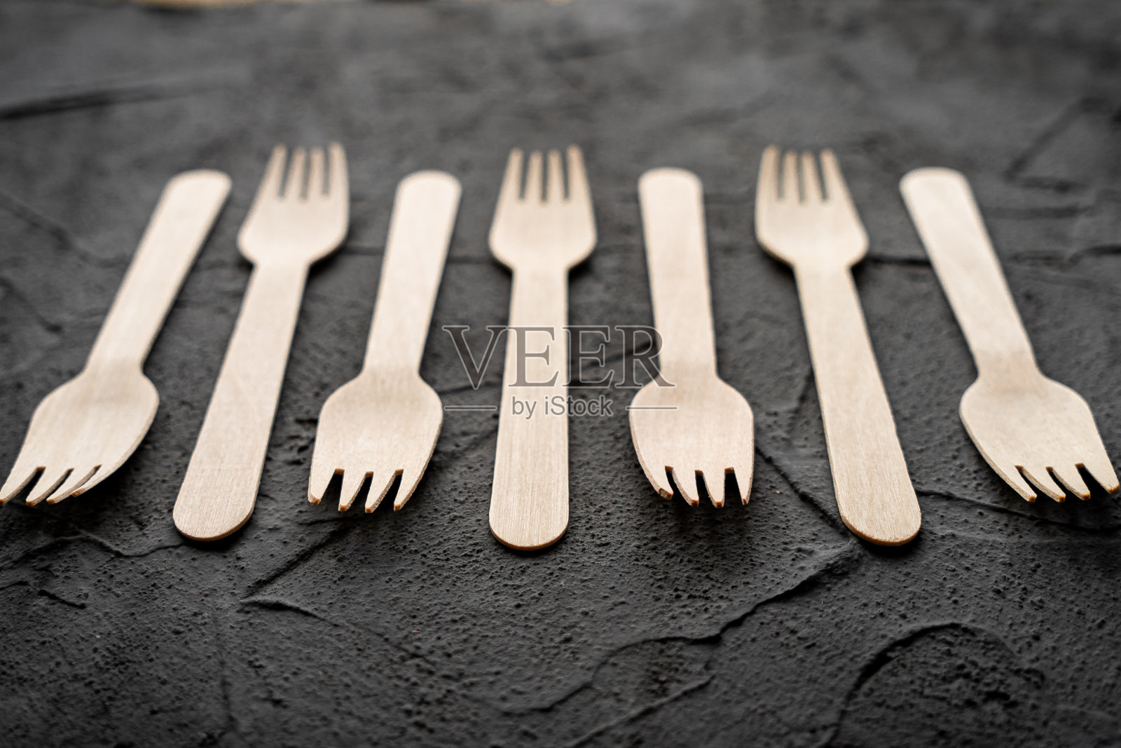 黑色背景上的木制刀叉。环保零浪费理念。带有文本空间的俯视图。本空间照片摄影图片