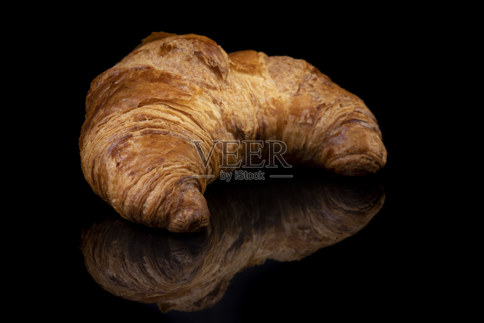 牛角面包在黑色反光工作室背景。孤立的黑色闪亮镜面镜面背景为每个概念。照片摄影图片