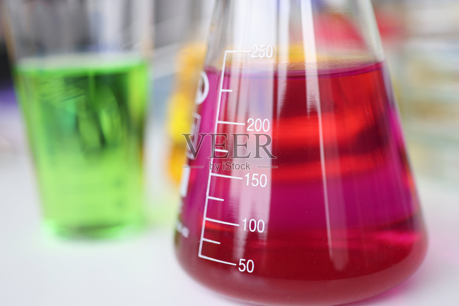 玻璃烧瓶与有色液体站在化学实验室的桌子特写照片摄影图片