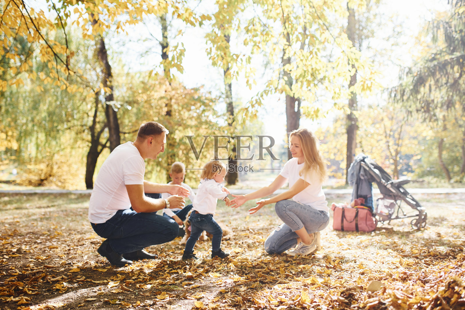 一个快乐的年轻的家庭一起在秋天的公园里休息照片摄影图片