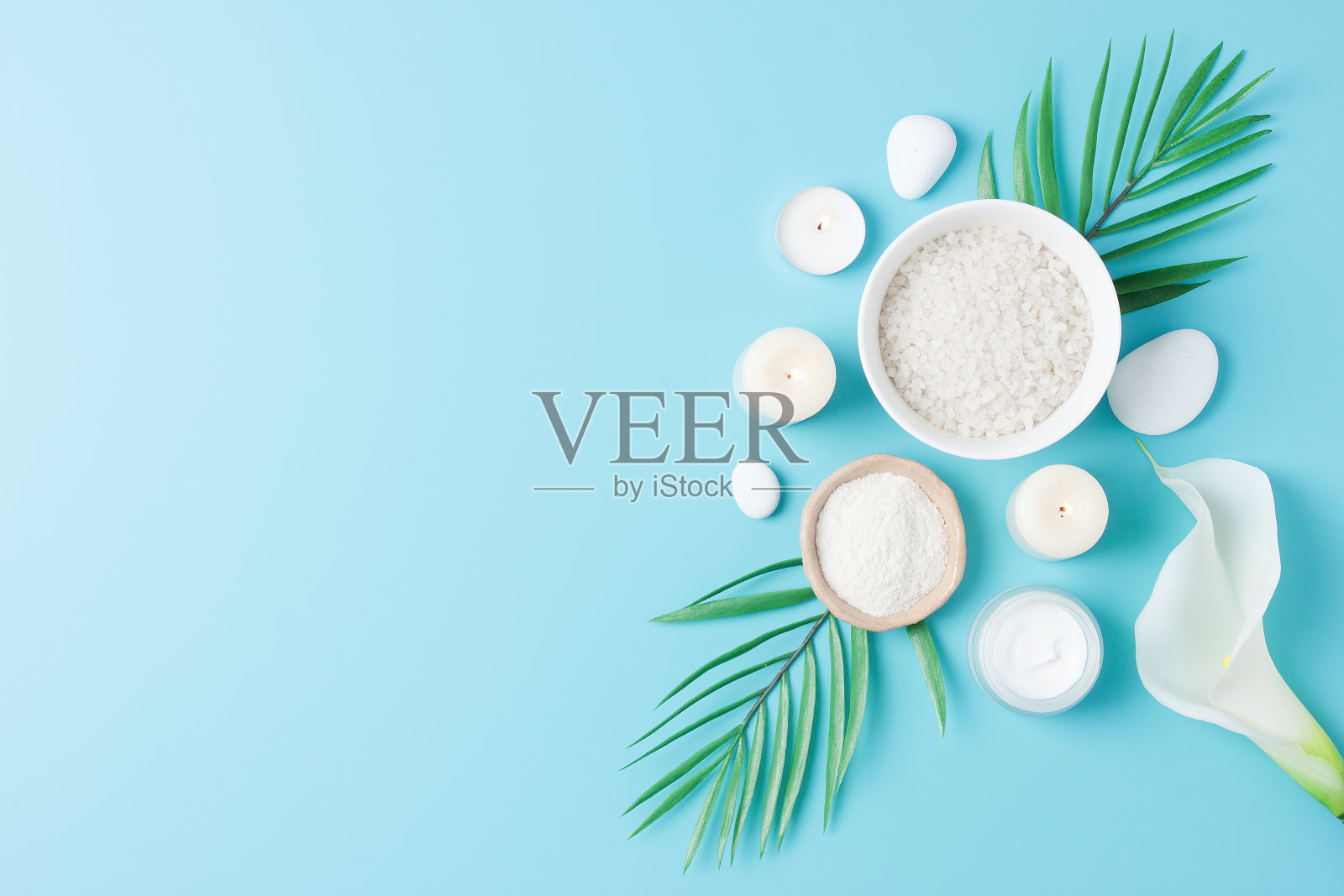 Spa的背景与护肤品，石头，蜡烛和棕榈叶上的蓝色。平铺，拷贝空间照片摄影图片