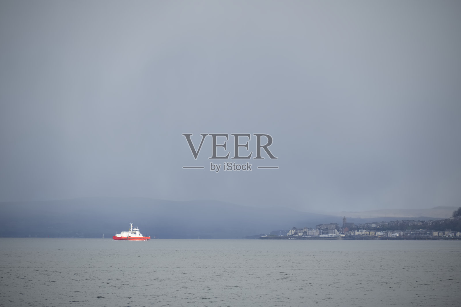 孤独的红船在深灰色的暴风雨天空下独自驶向古罗克照片摄影图片