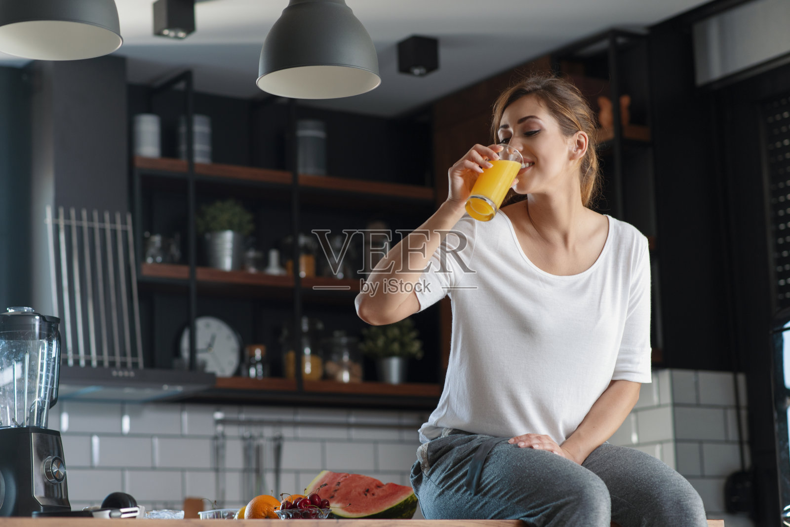 一个美丽的女人在室内喝着美味的果汁照片摄影图片