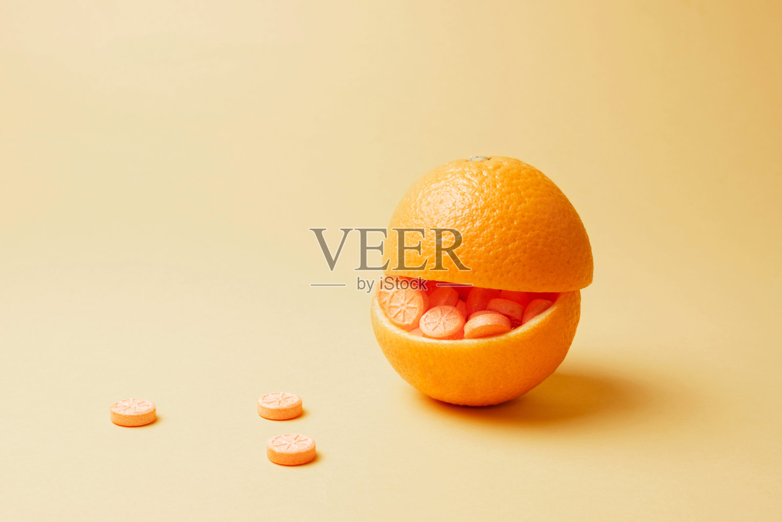 橙黄色的底色里塞满了橙黄色的药丸。维生素C丸作为柑橘类水果的替代品。照片摄影图片