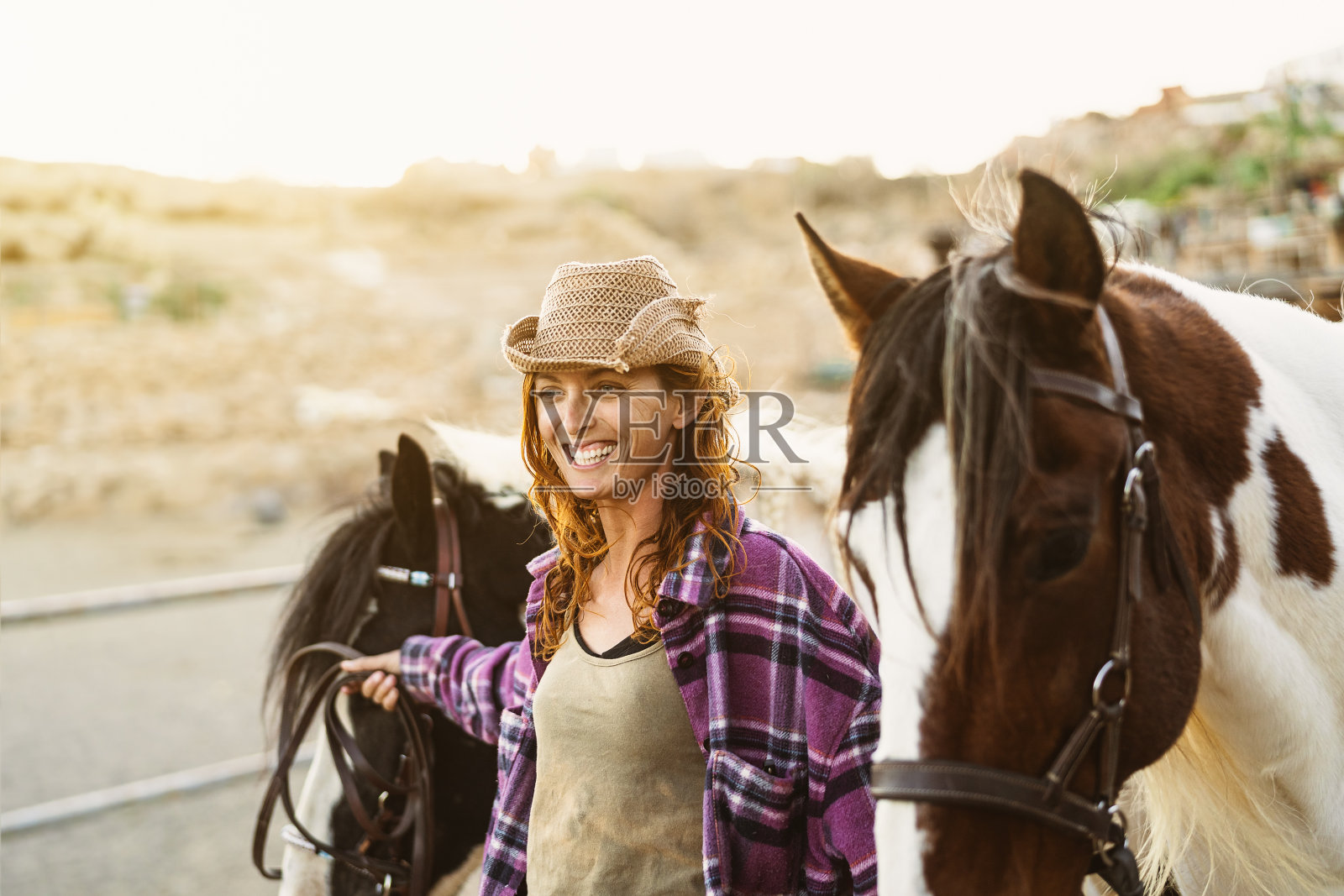 年轻微笑的农民在牧场的马厩里照顾马照片摄影图片