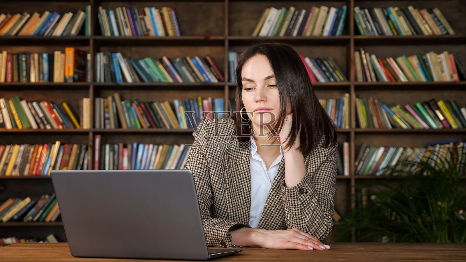 无聊的黑发短发看着笔记本显示器照片摄影图片