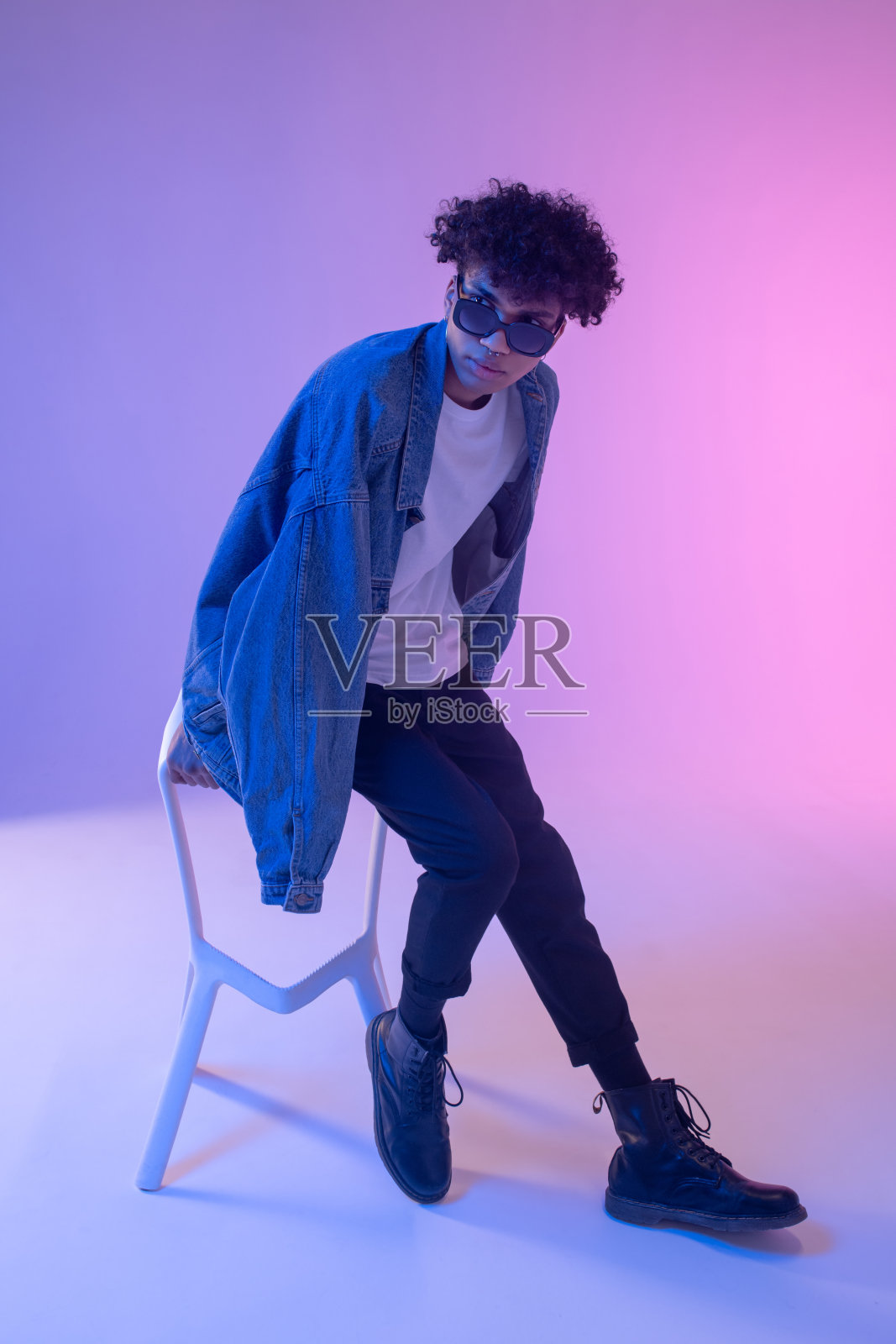 时尚的非洲裔美国男性模特在牛仔夹克摆姿势在工作室和看起来华丽照片摄影图片