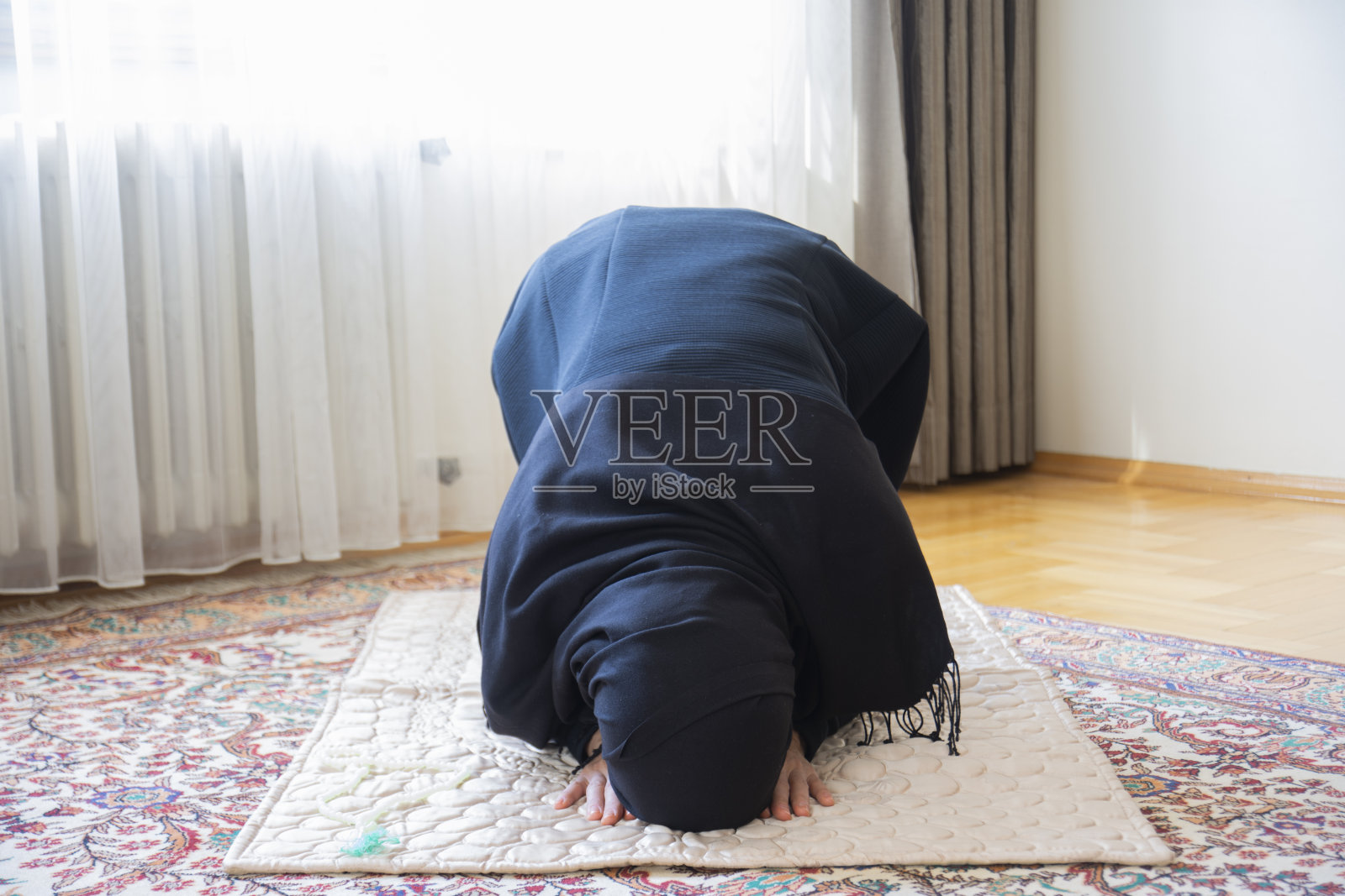 这位年轻的穆斯林妇女正在祈祷。照片摄影图片