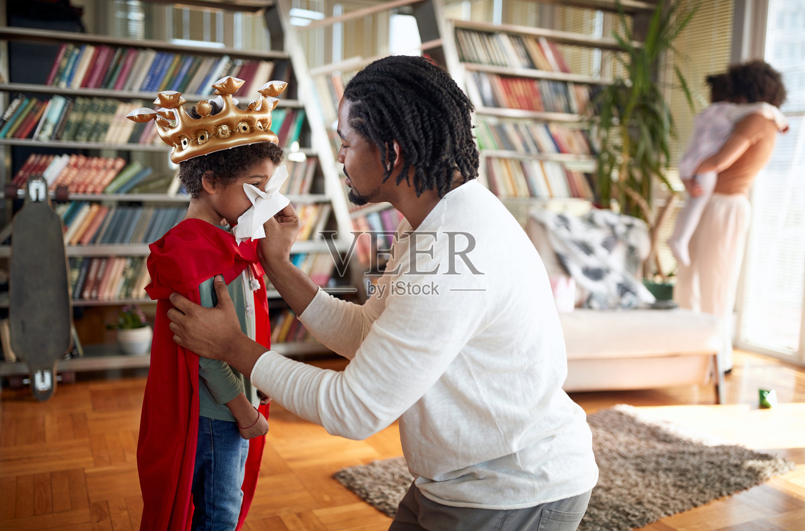 一个可爱的小男孩在他父亲的帮助下在家里搞砸了。家人，在一起，爱，玩耍的时间照片摄影图片