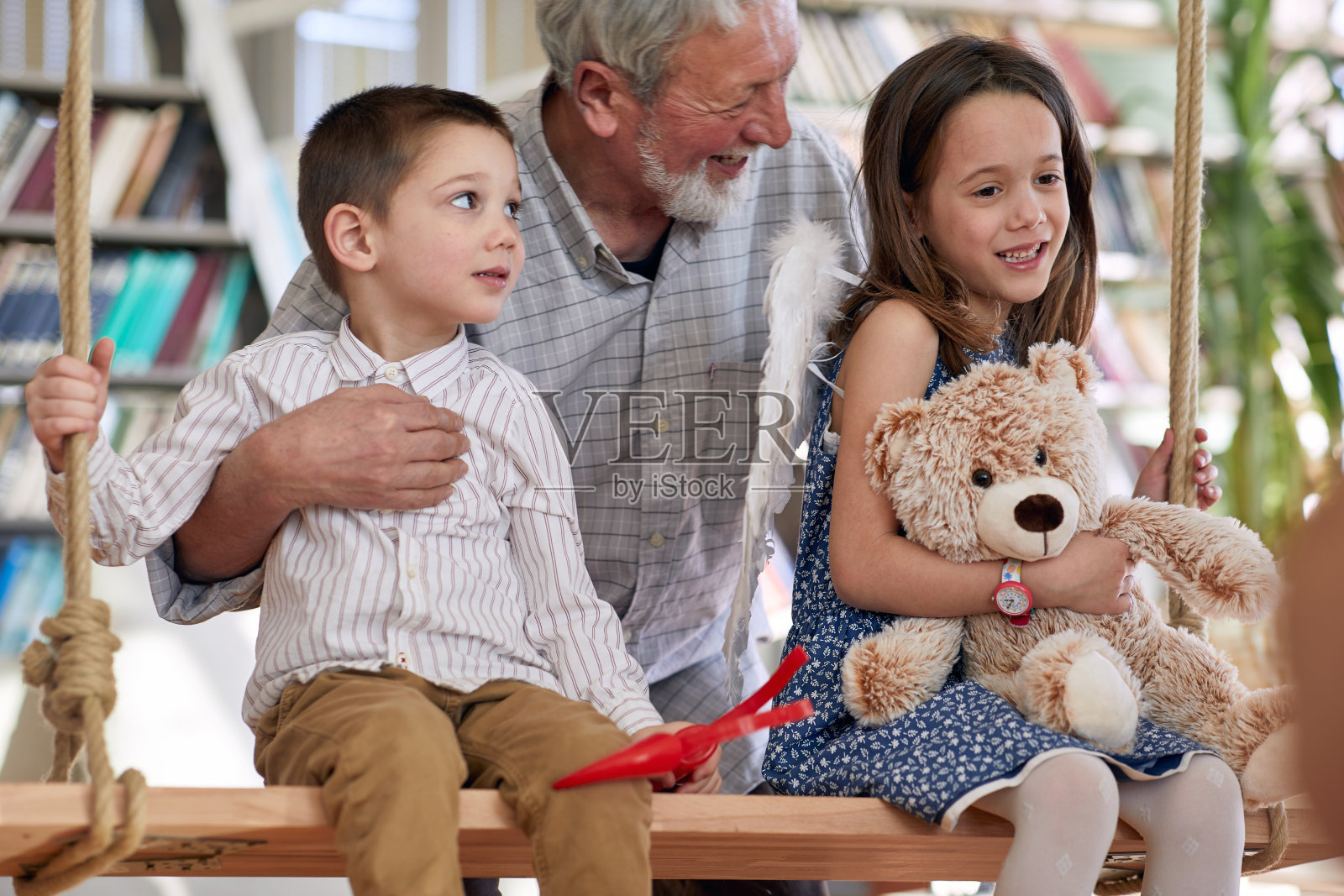 孙子们坐在秋千上和他们的爷爷在家里玩。家庭,家里,游戏时间照片摄影图片