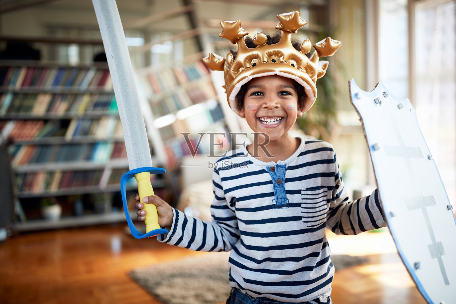 一个可爱的小男孩带着甜美的微笑在家里玩的时候摆姿势拍照。家人，在一起，爱，玩耍的时间照片摄影图片