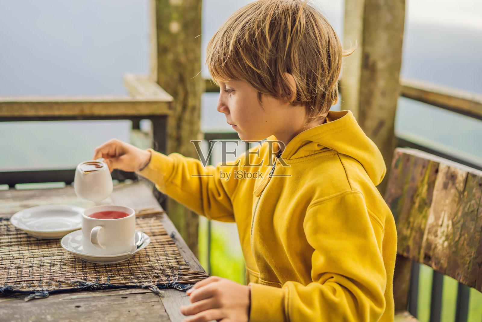 一个男孩在山里的咖啡馆喝茶照片摄影图片