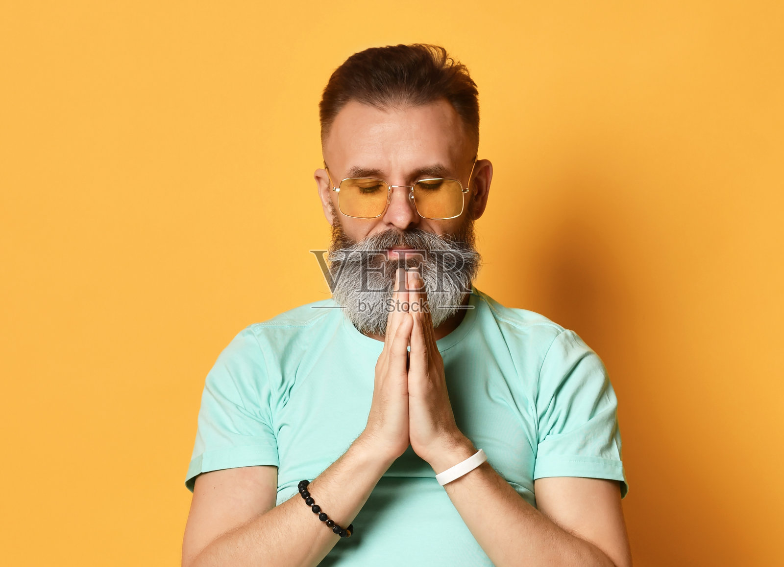 一个男人的肖像，他交叉双臂祈祷，祈求怜悯和同情照片摄影图片