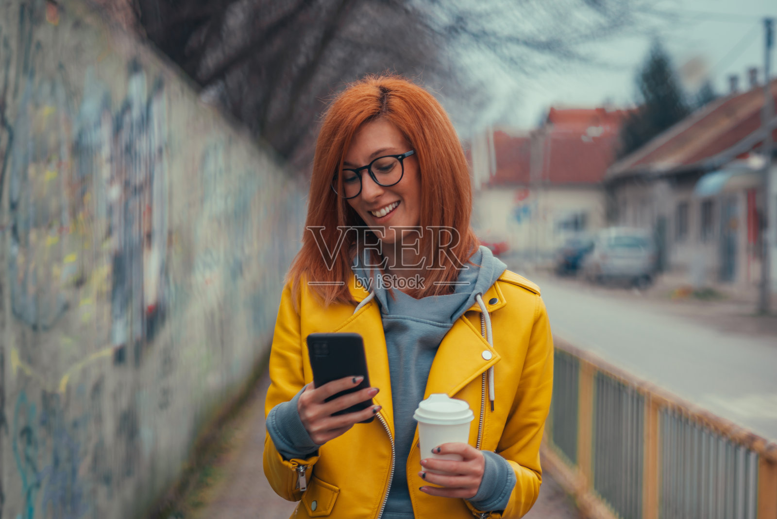 在外面用手机喝咖啡的女人照片摄影图片