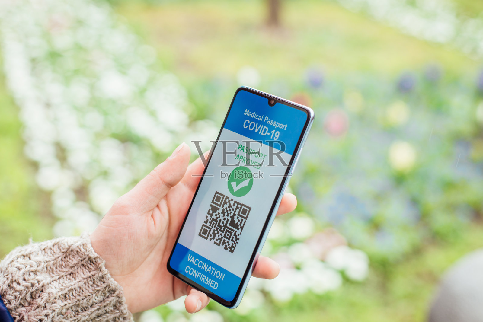 一个拿着电子疫苗证书的智能手机的陌生女人照片摄影图片