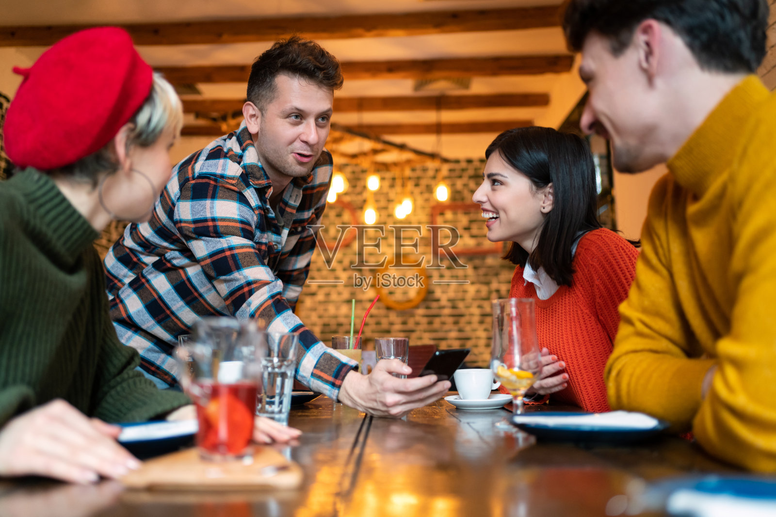一个男人在智能手机屏幕上给他的朋友们看东西照片摄影图片