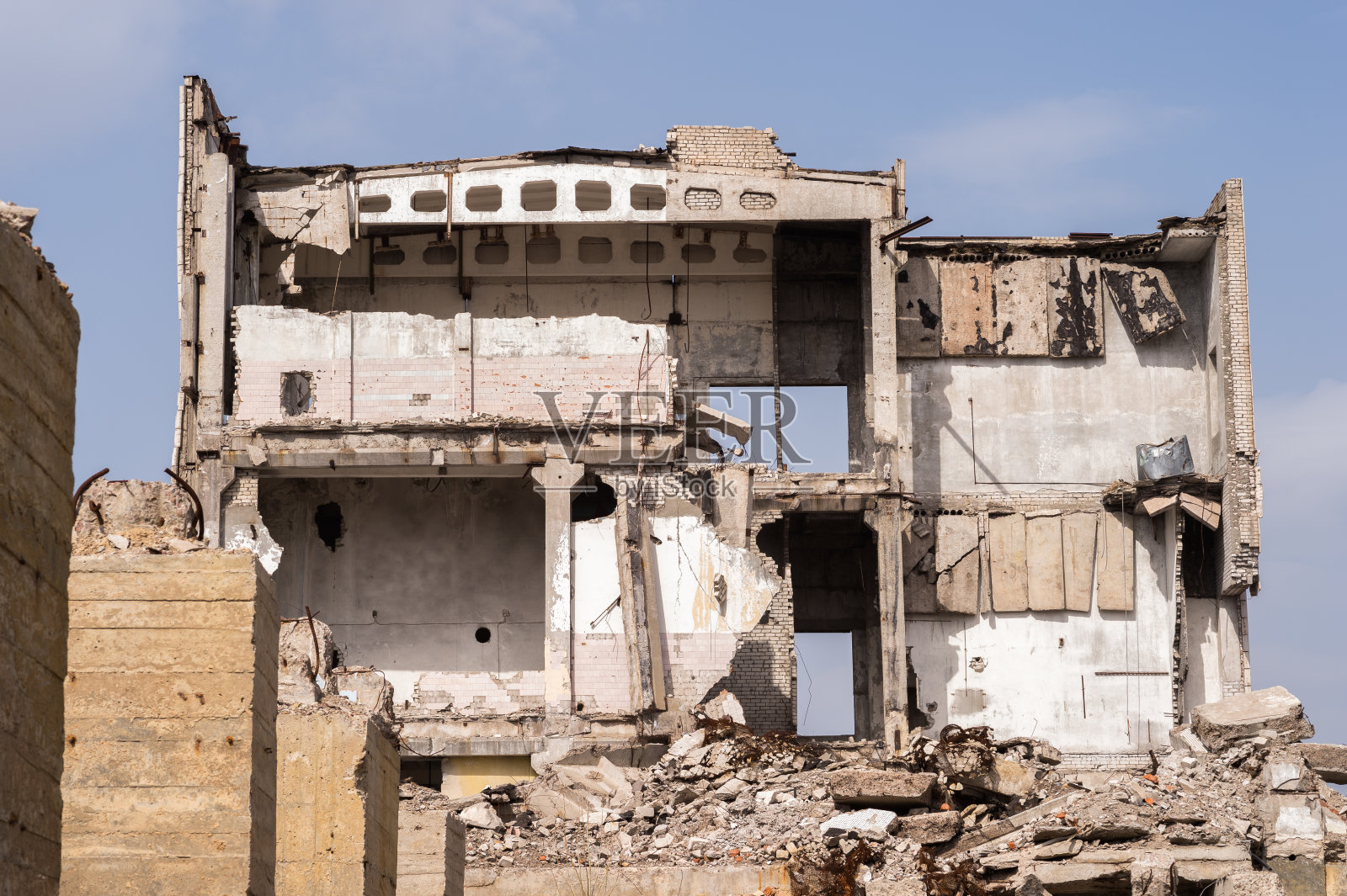 由混凝土碎石堆成的建筑废墟和被摧毁的建筑物的大型基桩。照片摄影图片