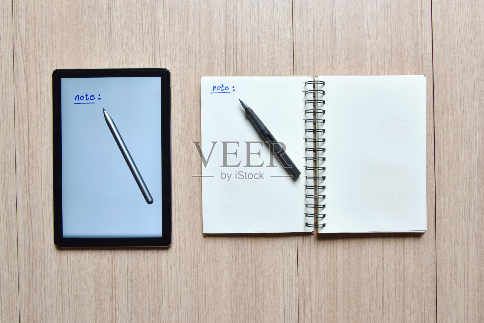 一个平板电脑和笔记本与笔在木桌上，新旧风格的技术记录，并采取备忘录的笔记或清单的概念照片摄影图片