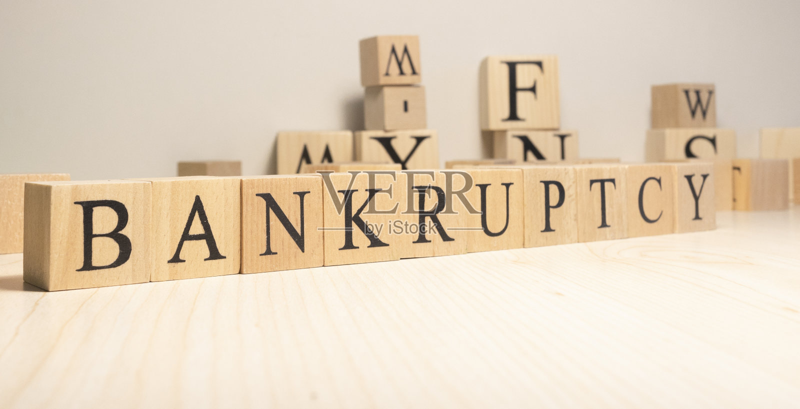 “破产”这个词来自木制立方体。背景来自木制字母。照片摄影图片