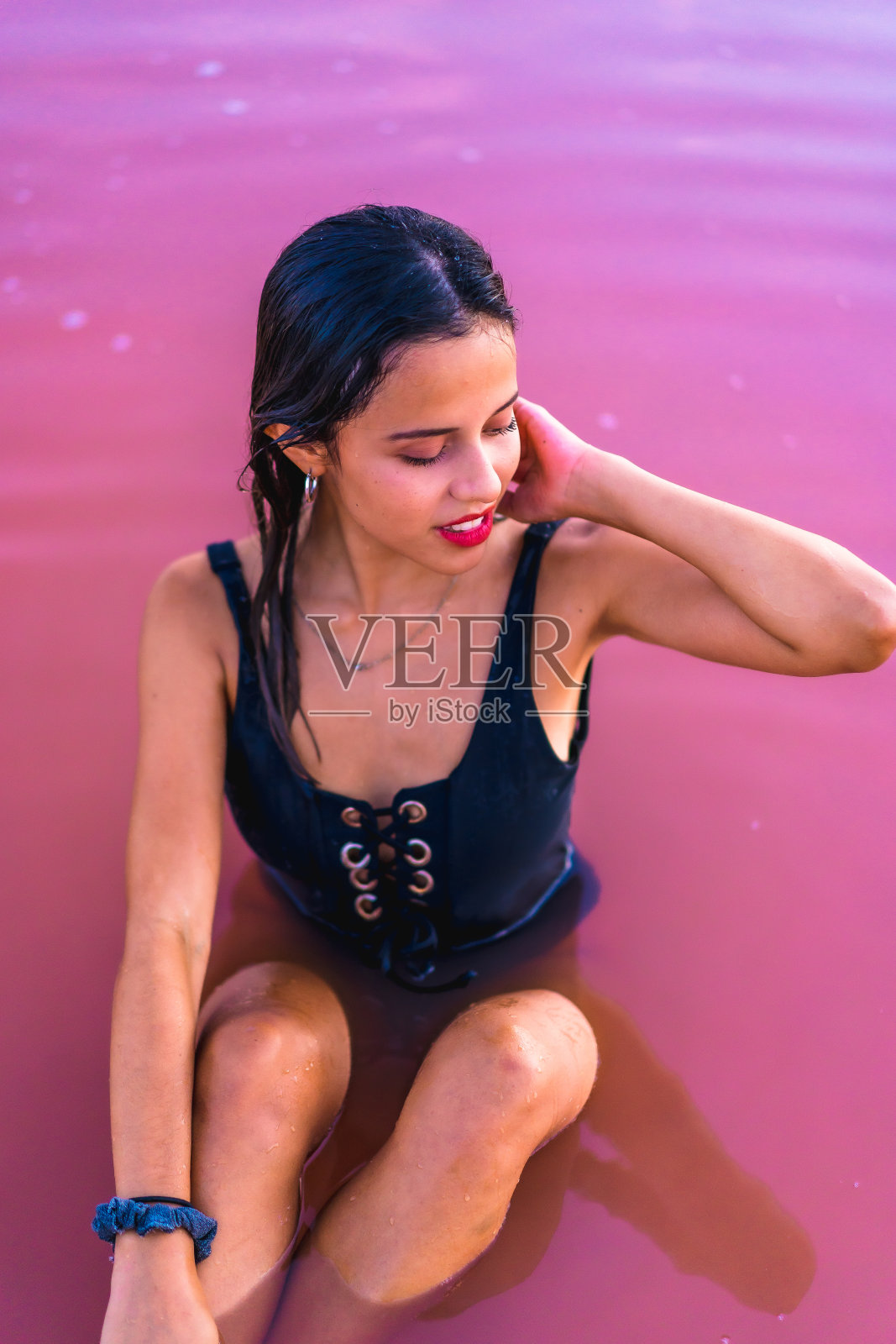 一个年轻的黑发白种人在托雷维哈的粉色泻湖的暑假，玩水，阿利坎特。西班牙照片摄影图片