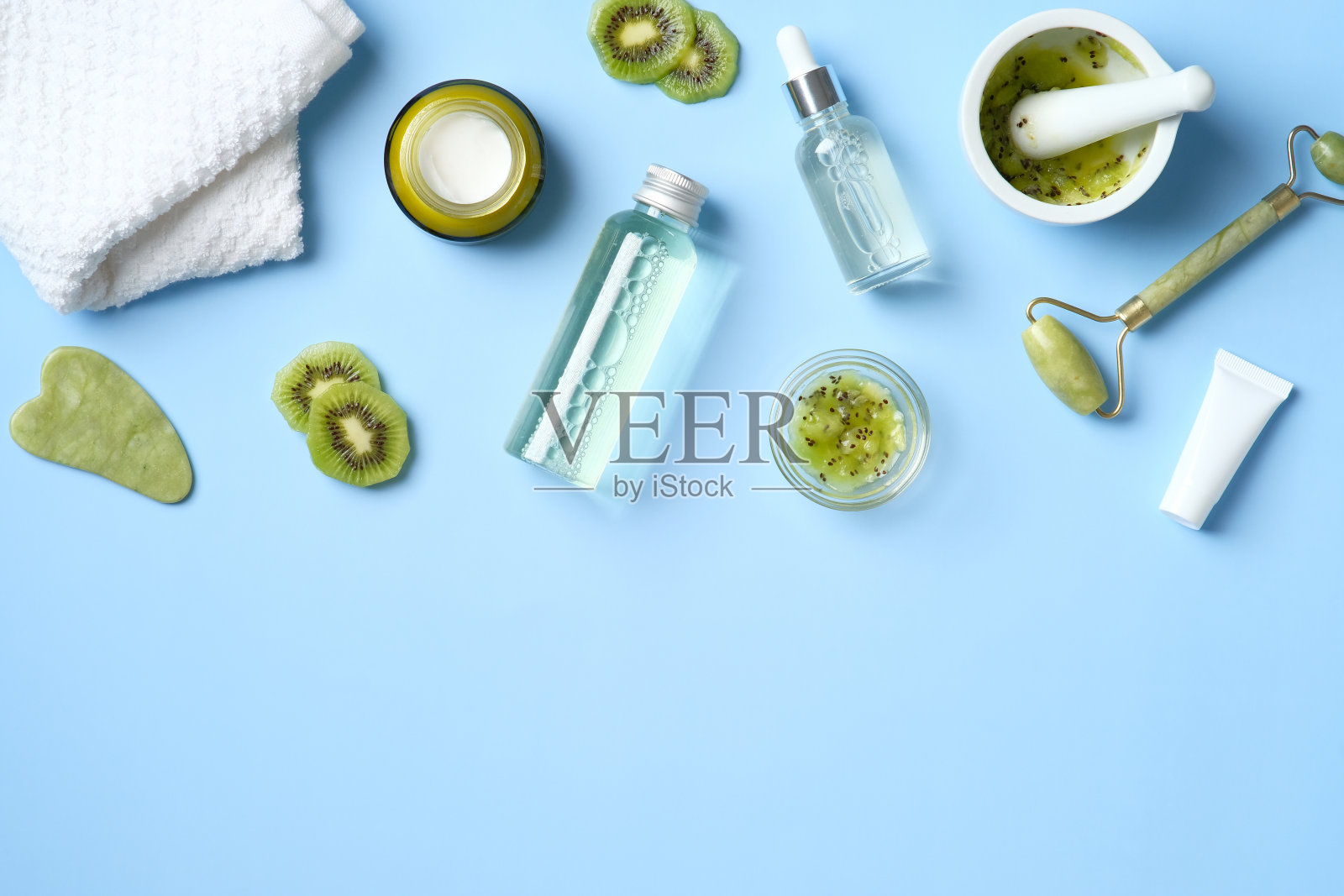 天然有机SPA美容产品集猕猴桃。俯视图草药护肤美容产品上的蓝色背景。美容沙龙横幅模型。平铺极简风格照片摄影图片