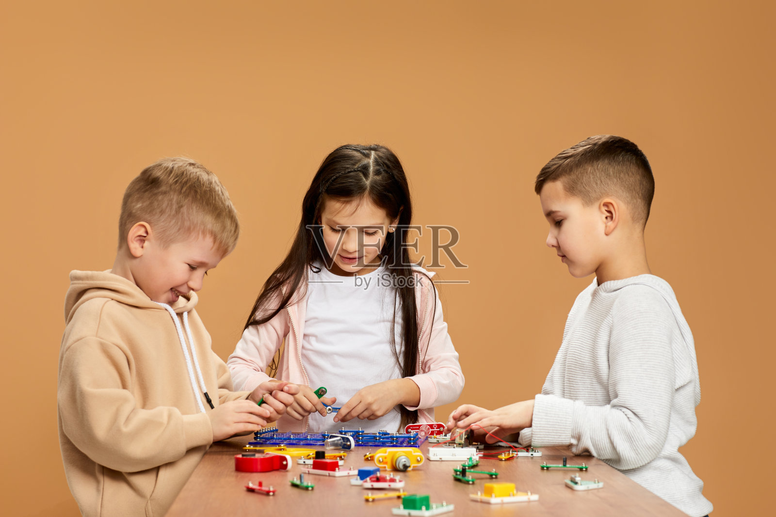 热情的孩子们在工作室收集电子电路照片摄影图片