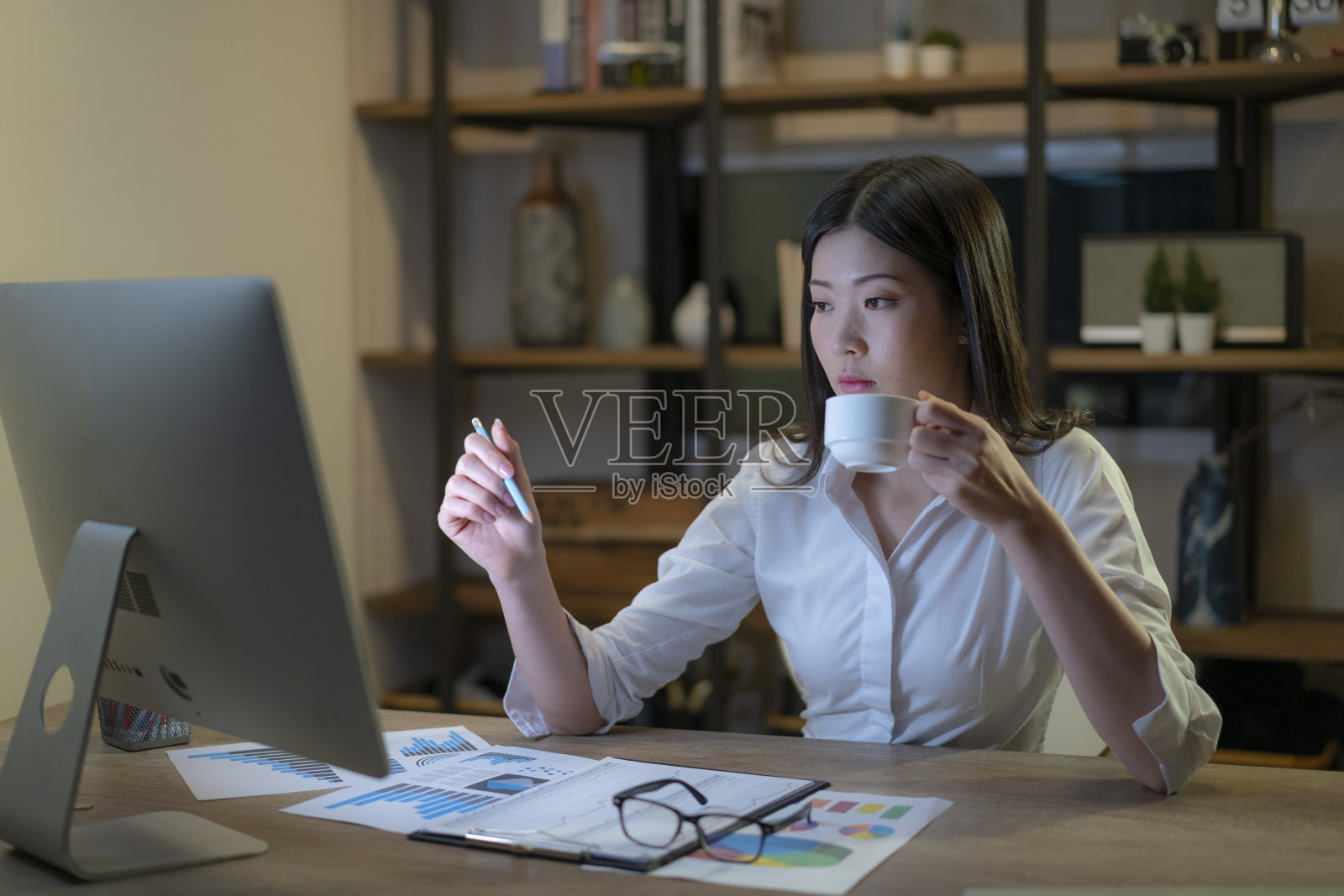 亚洲女性在深夜使用个人电脑工作。照片摄影图片