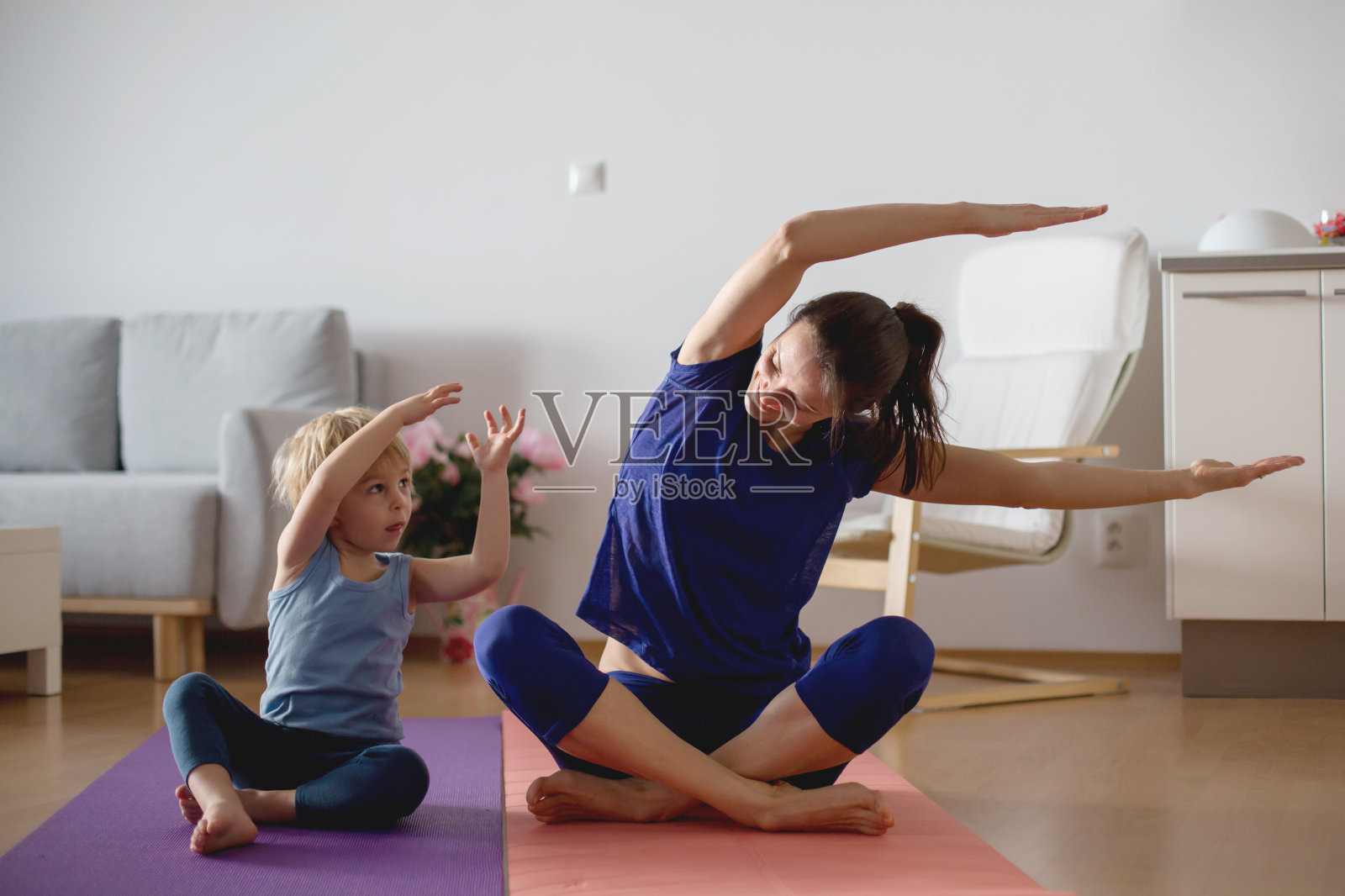 冠状病毒感染期间，母亲和孩子在家锻炼，人们在家做体操照片摄影图片