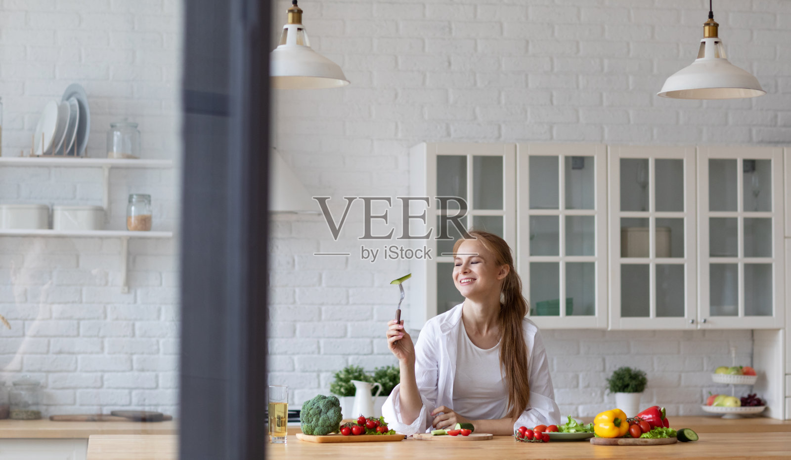 年轻女子在厨房做饭。照片摄影图片