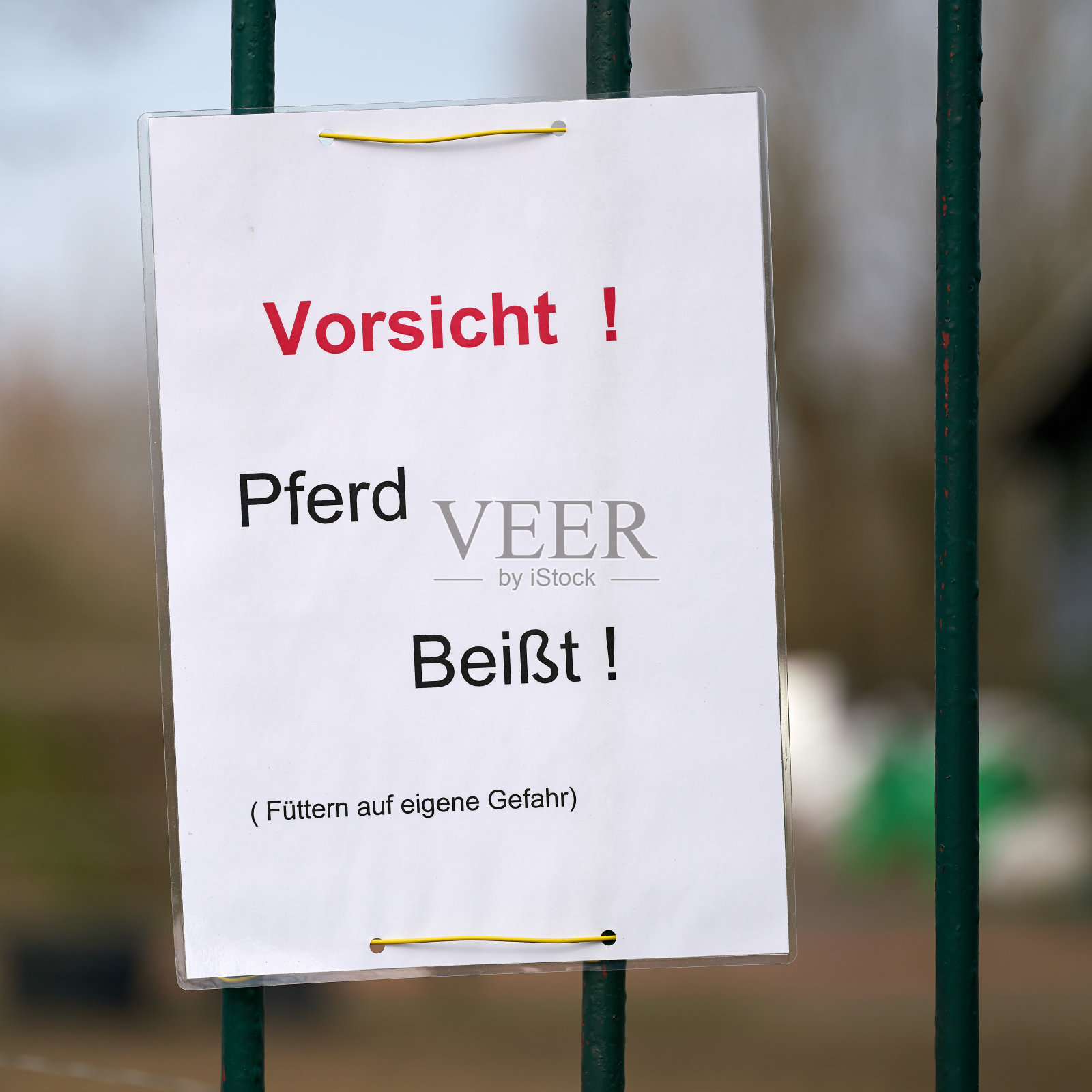 在篱笆上签上“小心被马咬”的字样照片摄影图片