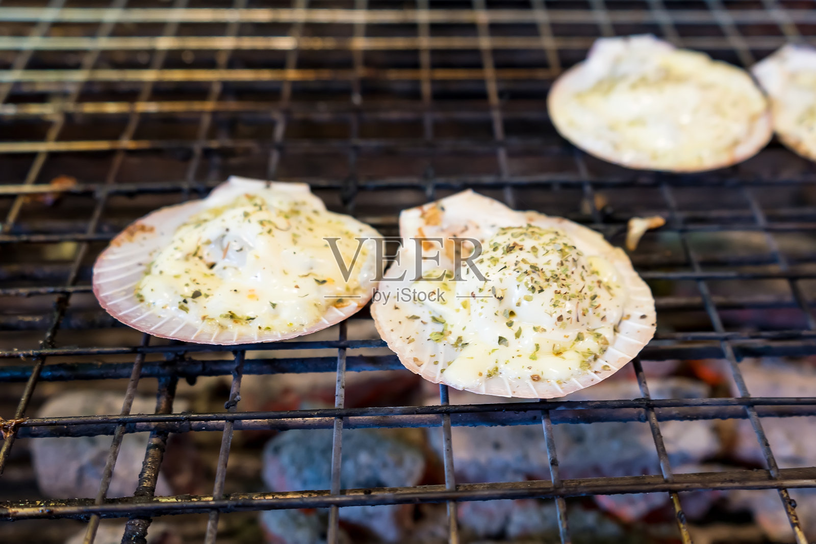 火烤扇贝，炭炉烤芝士扇贝，泰式海鲜配酸辣海鲜蘸汁。这种食物也能御寒。照片摄影图片