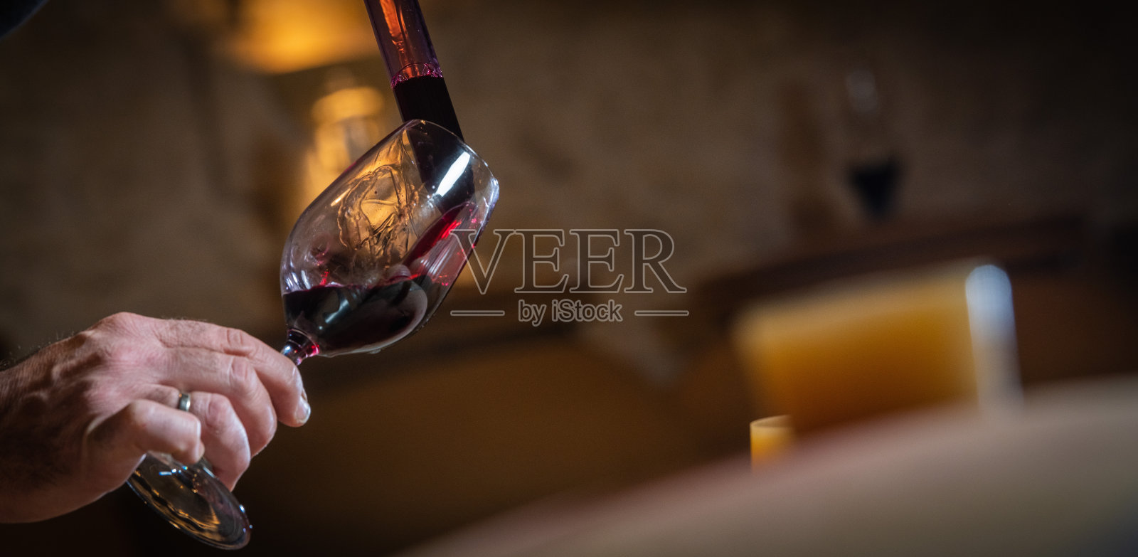 法国，吉隆，圣爱美浓，用移液管在酒桶中品尝一杯葡萄酒，并监测酿造过程照片摄影图片