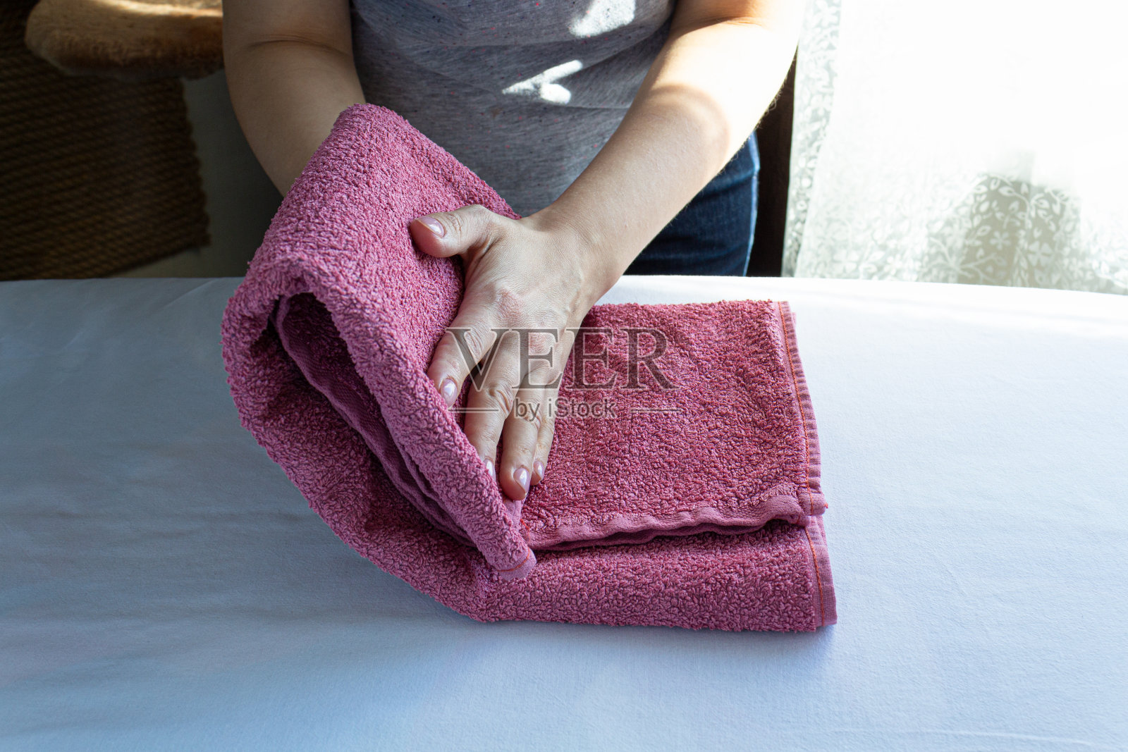 那个女人叠衣服。家务,检疫照片摄影图片