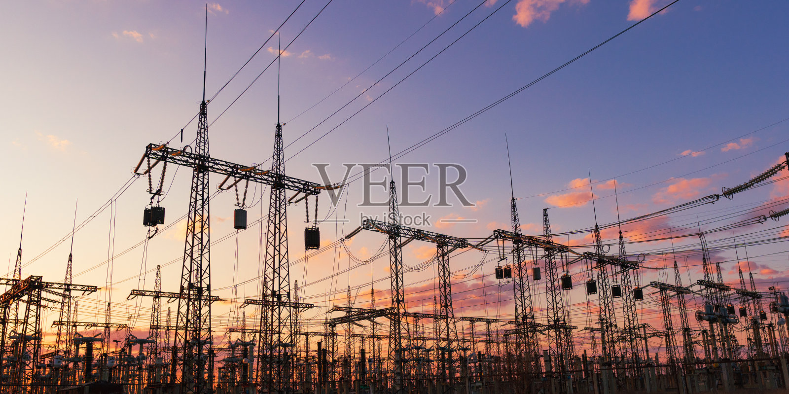 在日出时，彩色天空映衬着高压电线的剪影。照片摄影图片