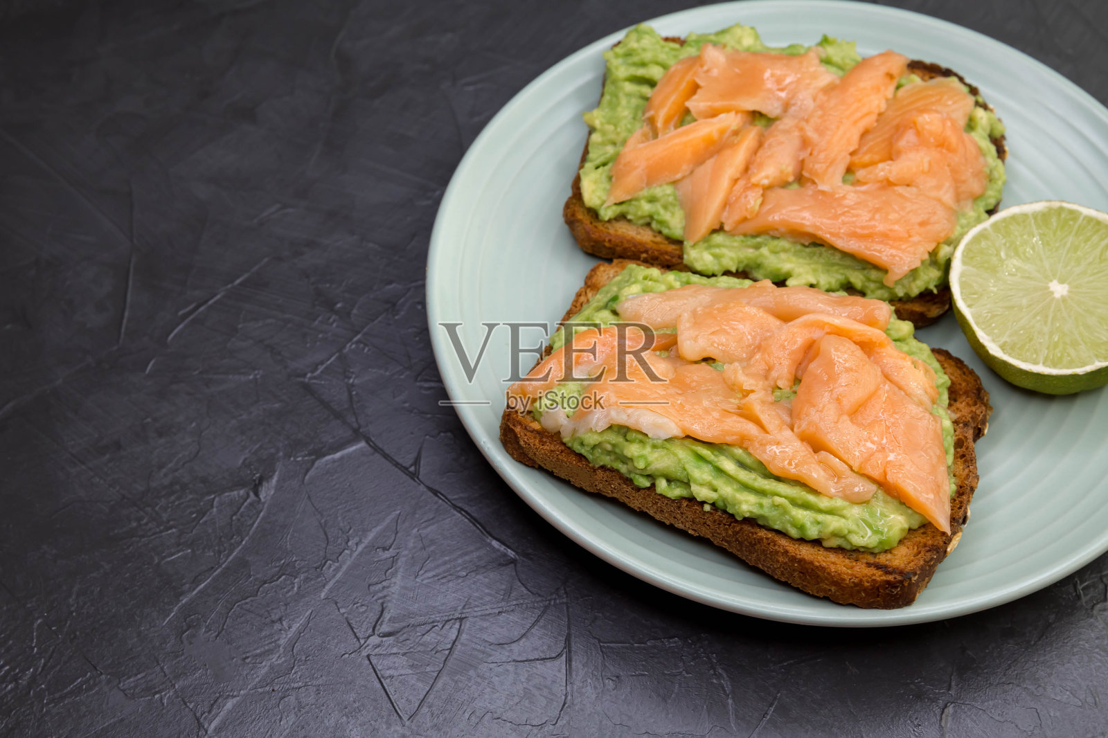 美味的三明治配黑麦面包，鳄梨和鲑鱼。健康的食物照片摄影图片