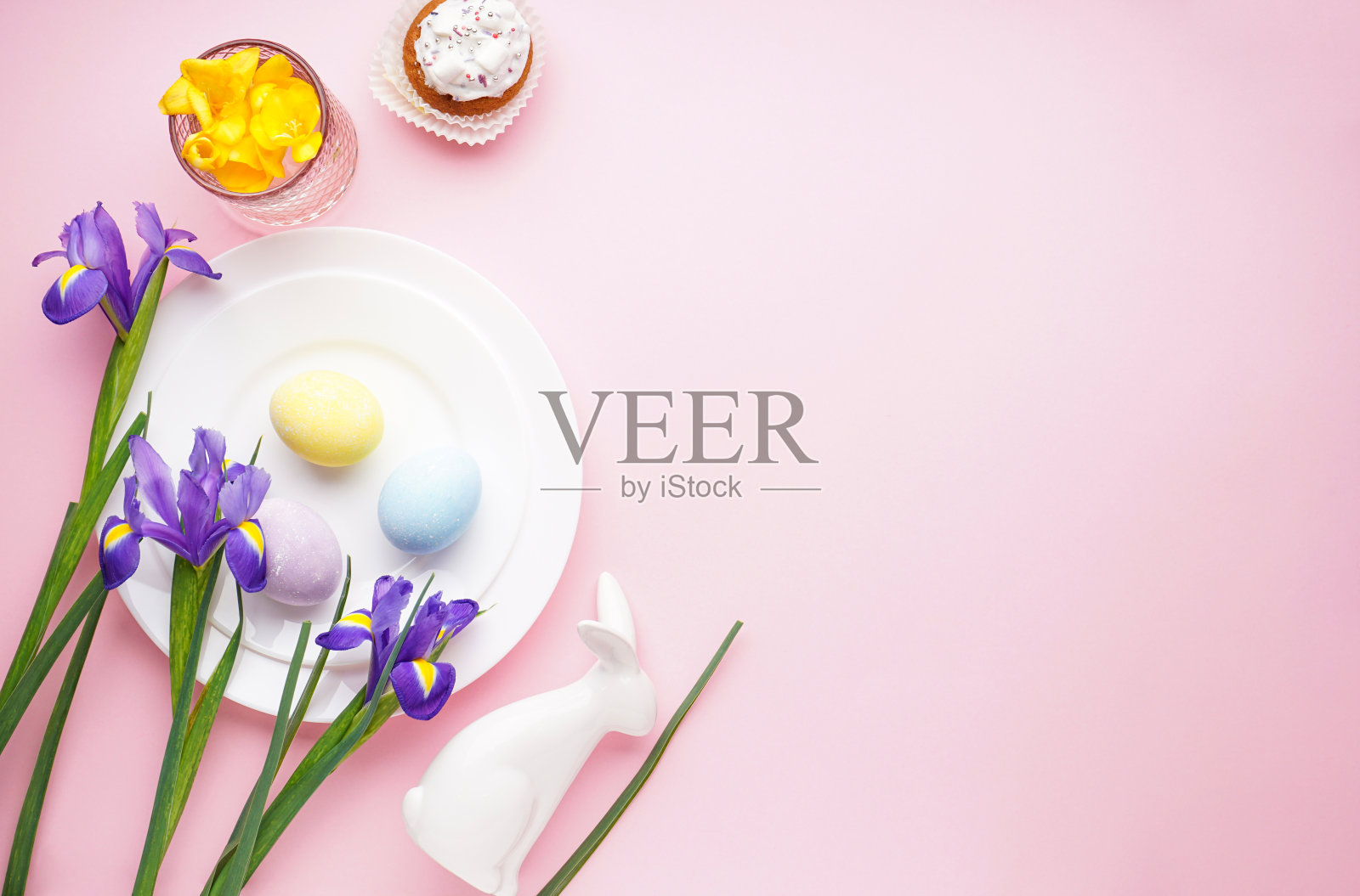 复活节餐桌设置和盘子与彩色彩蛋在粉红色的背景。俯视图，文本空间。照片摄影图片