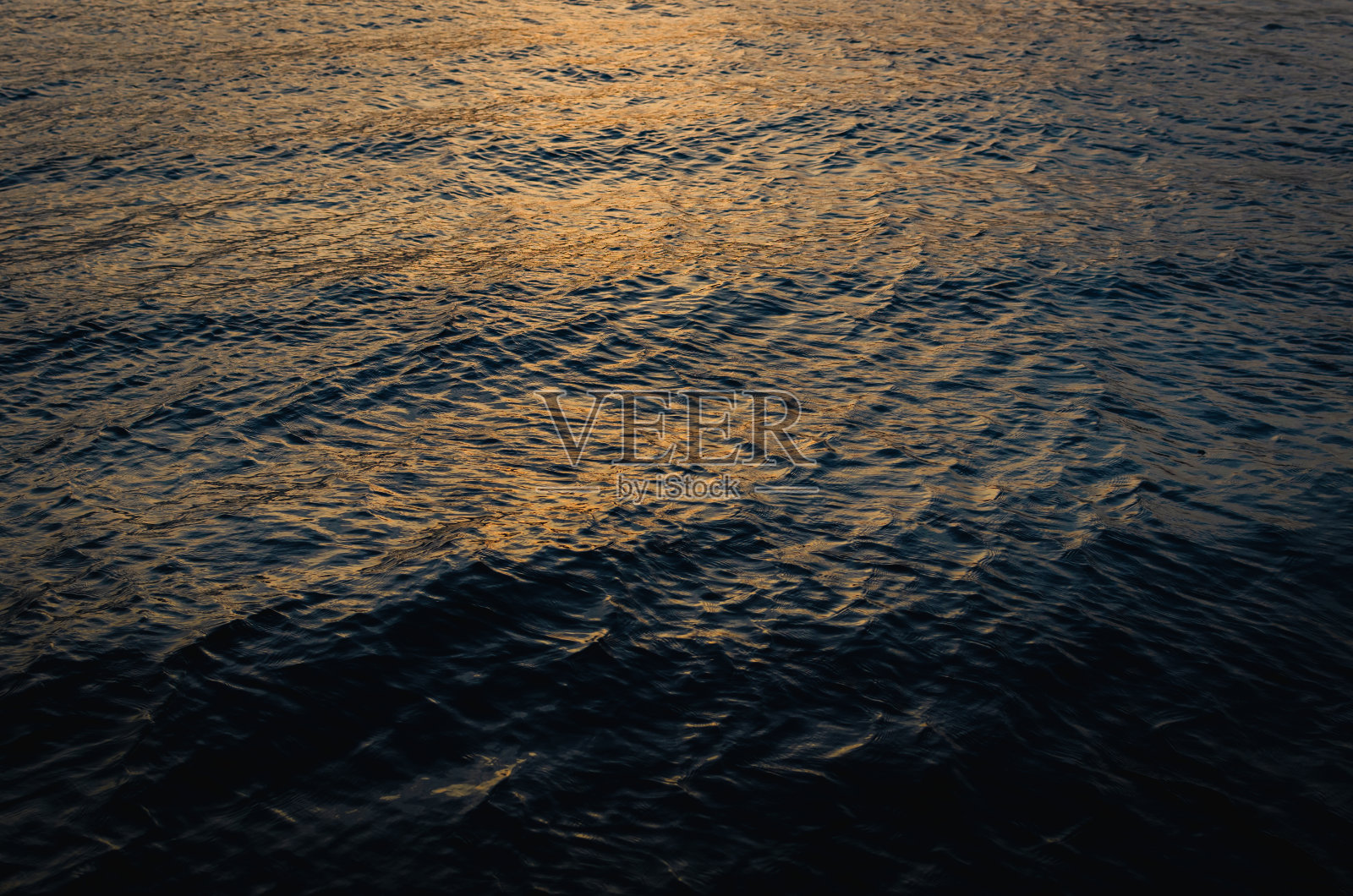 深蓝色的水面，阳光照在水面上照片摄影图片