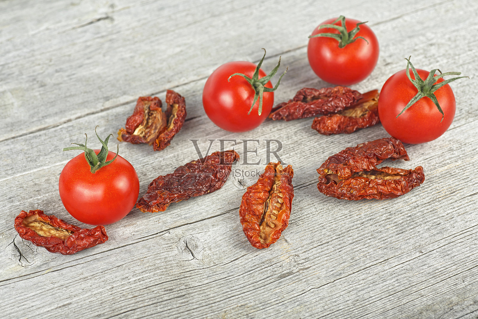 传统的地中海厨房-美味的番茄干和新鲜的番茄在木桌上。照片摄影图片