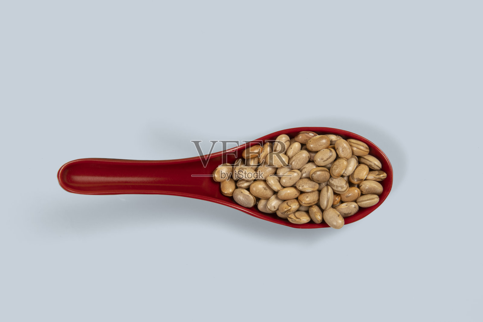 在红色塑料碗里晾干花豆种子照片摄影图片