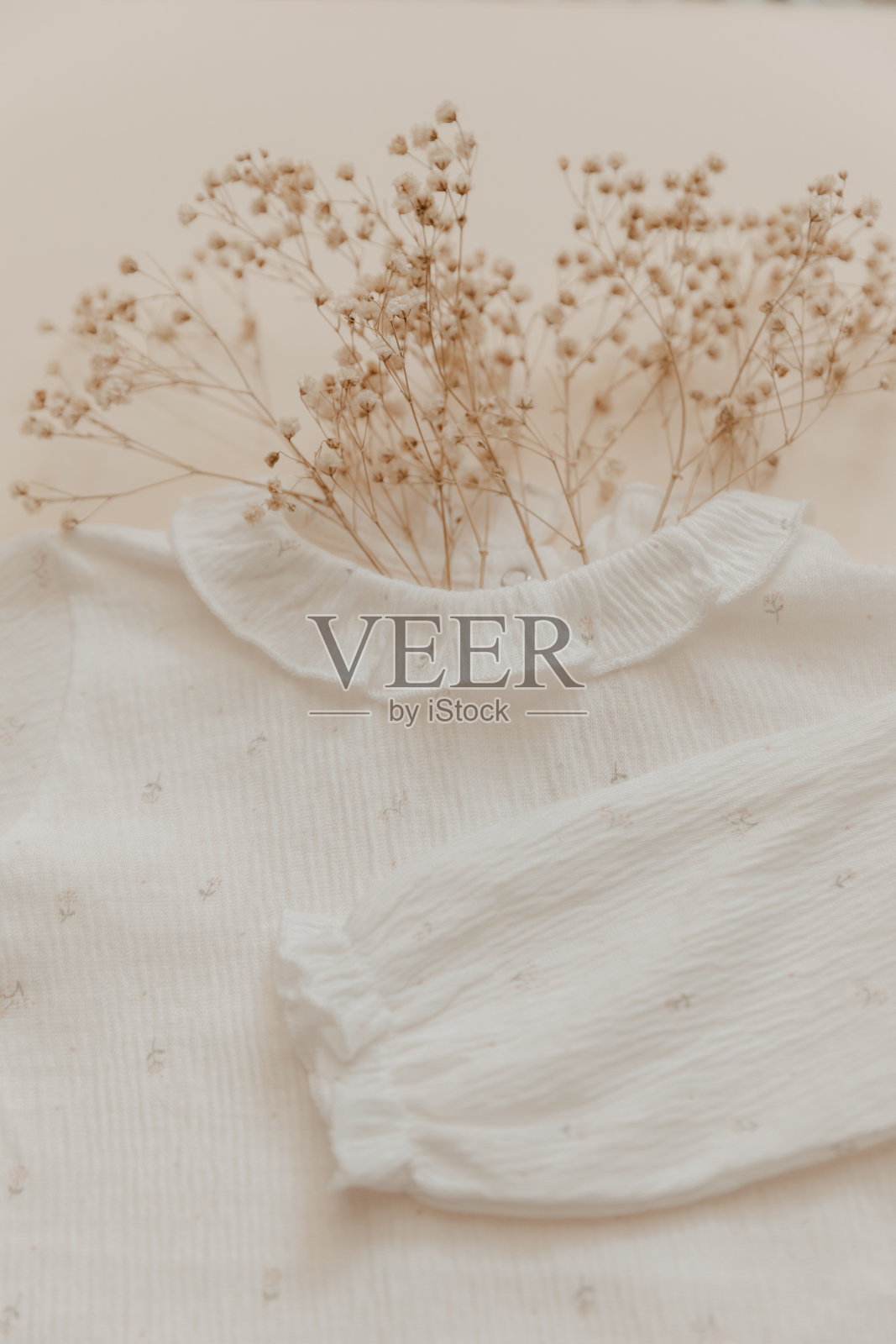 天然材料的概念。柔软的婴儿紧身衣米色背景。放荡不羁的孩子照片摄影图片