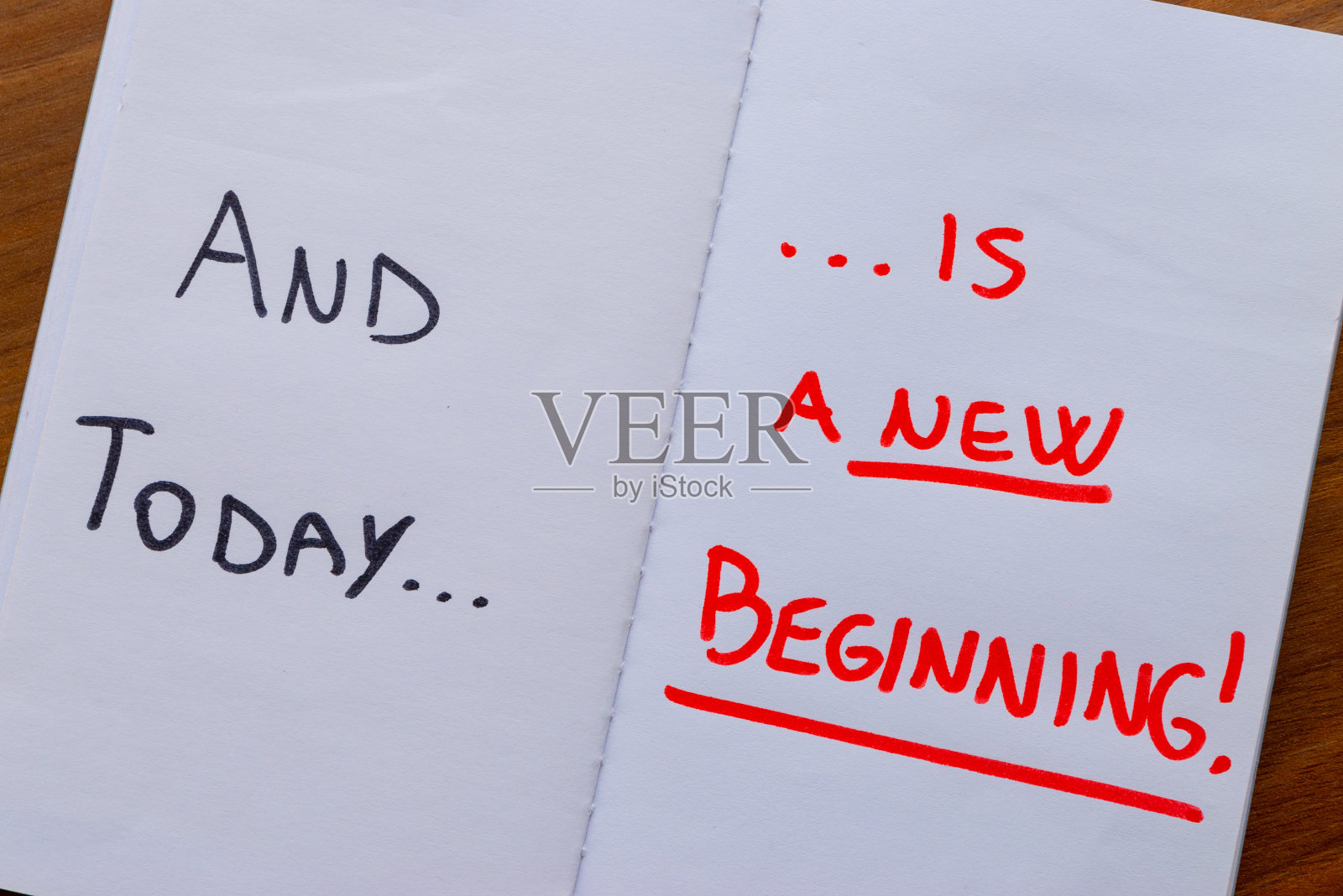 白纸上写着“今天是一个新的开始”。照片摄影图片