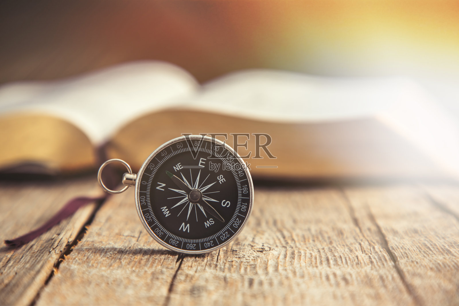 桌上放着书的指南针照片摄影图片