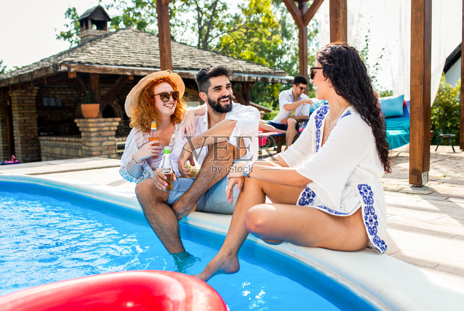 一群朋友在暑假享受在泳池边的派对。照片摄影图片